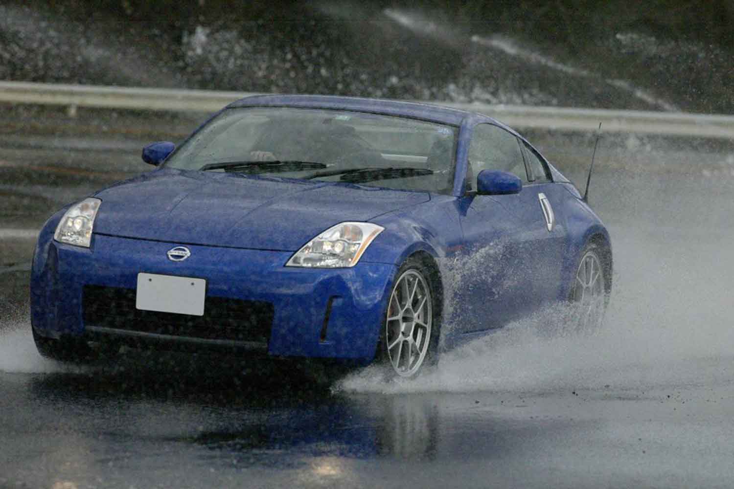 濡れた路面を走る青いスポーツカー